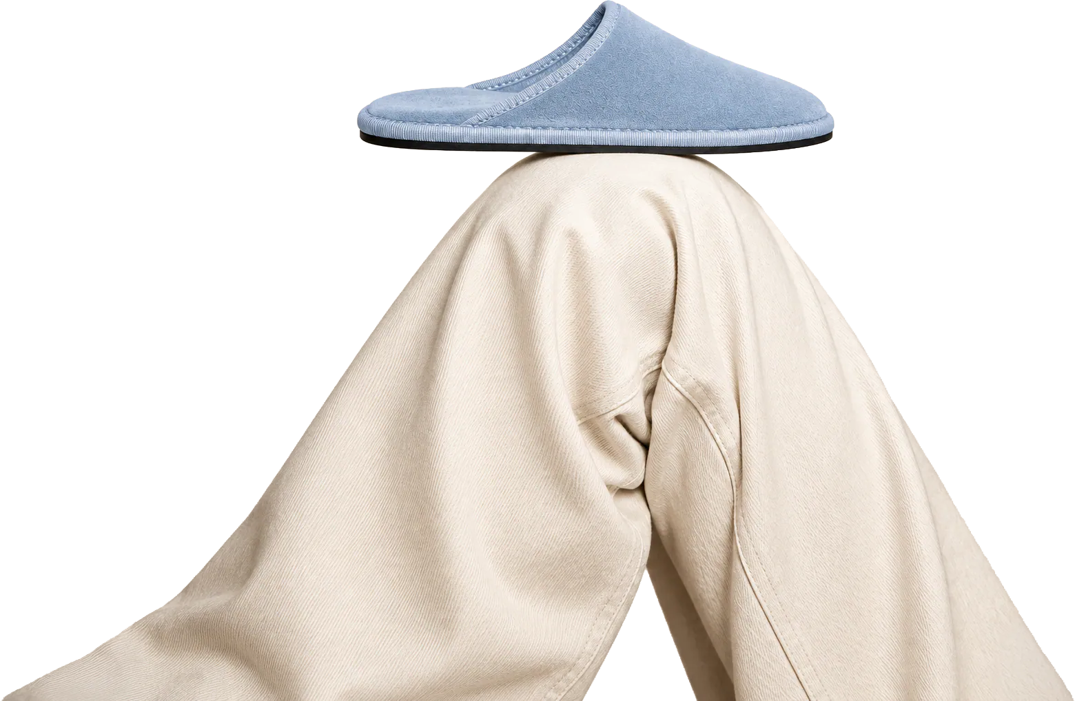 A pale blue Le Furlé slipper balanced on raised knees in oversized cream trousers